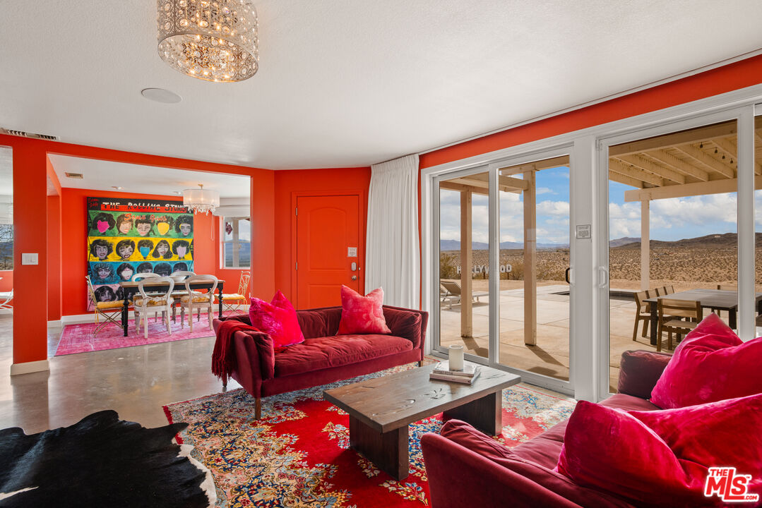 64425 Carot Road Joshua Tree, CA 92252 - Photo 16 of 73 a living room with furniture and a floor to ceiling window