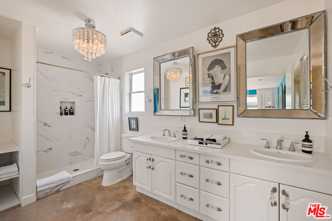 64425 Carot Road Joshua Tree, CA 92252 - Photo 32 of 73 a bathroom with double vanity sinks a toilet a mirror and shower