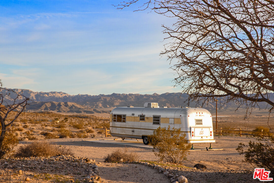 64425 Carot Road Joshua Tree, CA 92252 - Photo 47 of 73 a front view of a house with a yard and mountain view in back