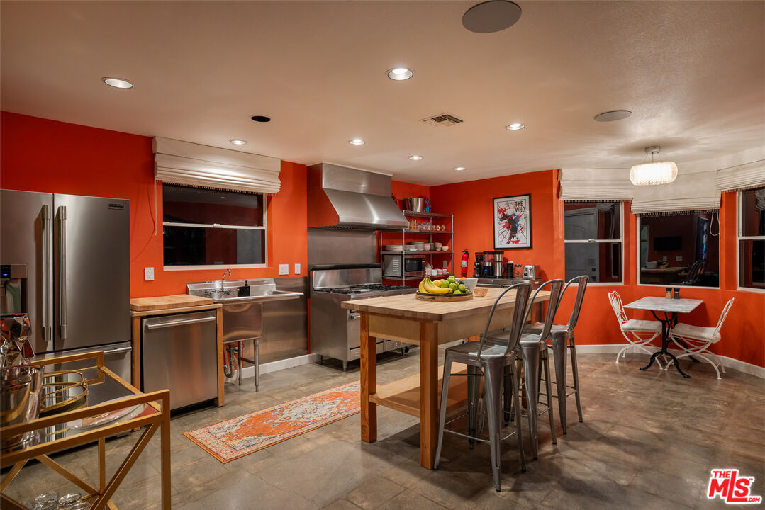 64425 Carot Road Joshua Tree, CA 92252 - Photo 65 of 73 a kitchen with stainless steel appliances kitchen island granite countertop a table chairs and a refrigerator