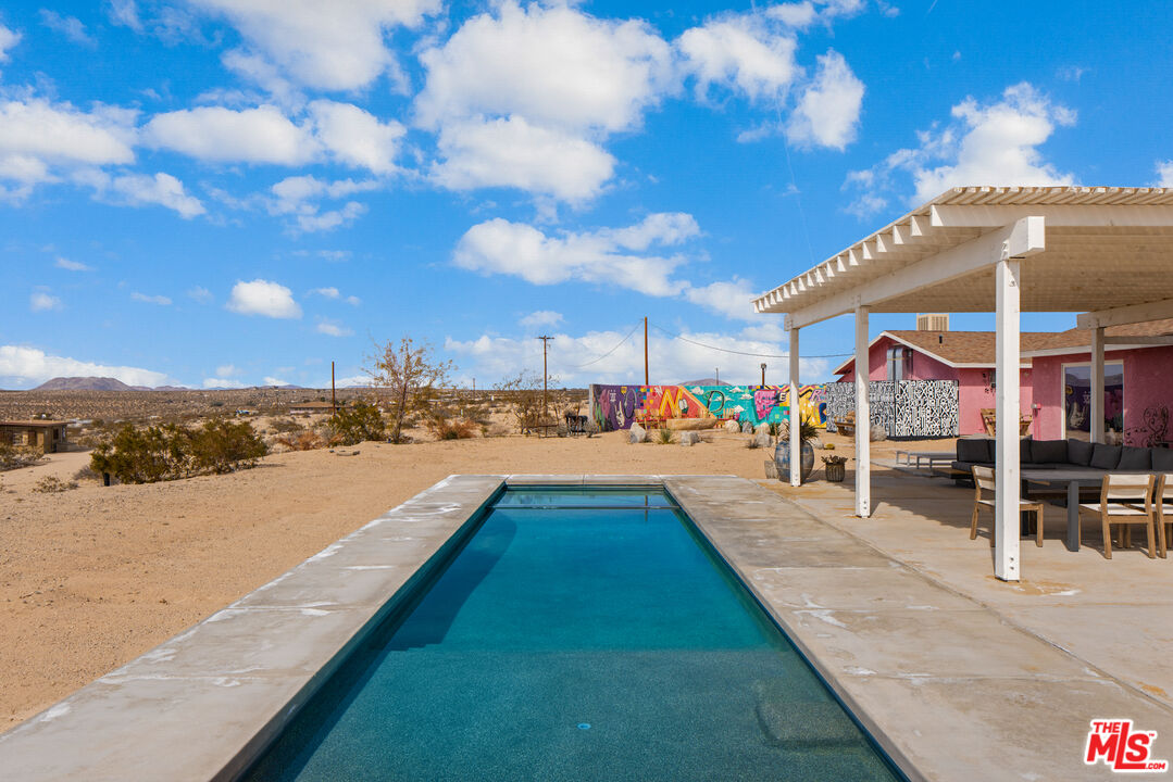 64425 Carot Road Joshua Tree, CA 92252 - Photo 9 of 73 a view of swimming pool with a table and chairs under an umbrella
