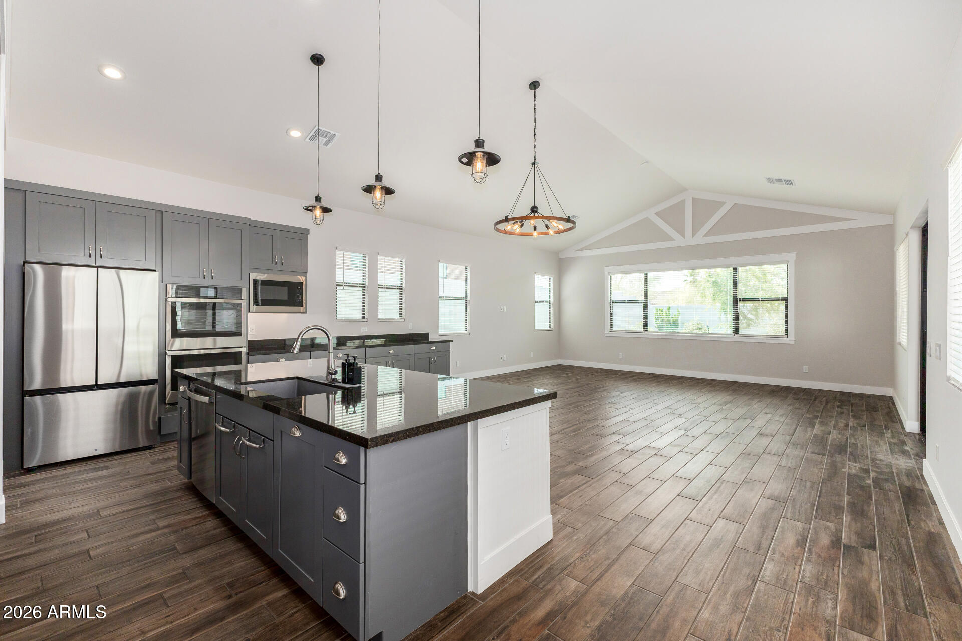 9818 South 7th Place Phoenix, AZ 85042 - Photo 11 of 62 a kitchen with stainless steel appliances granite countertop a sink a stove and a wooden floors