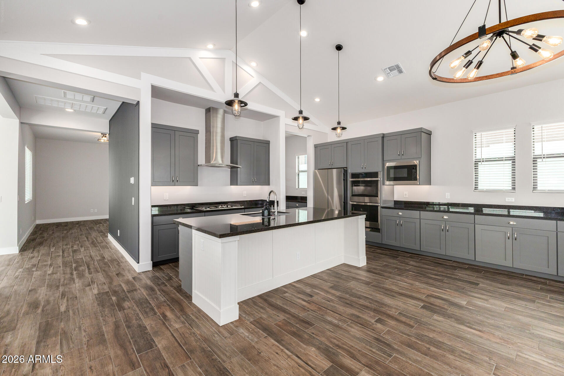 9818 South 7th Place Phoenix, AZ 85042 - Photo 12 of 62 a large kitchen with stainless steel appliances kitchen island a large counter top and a wooden floors