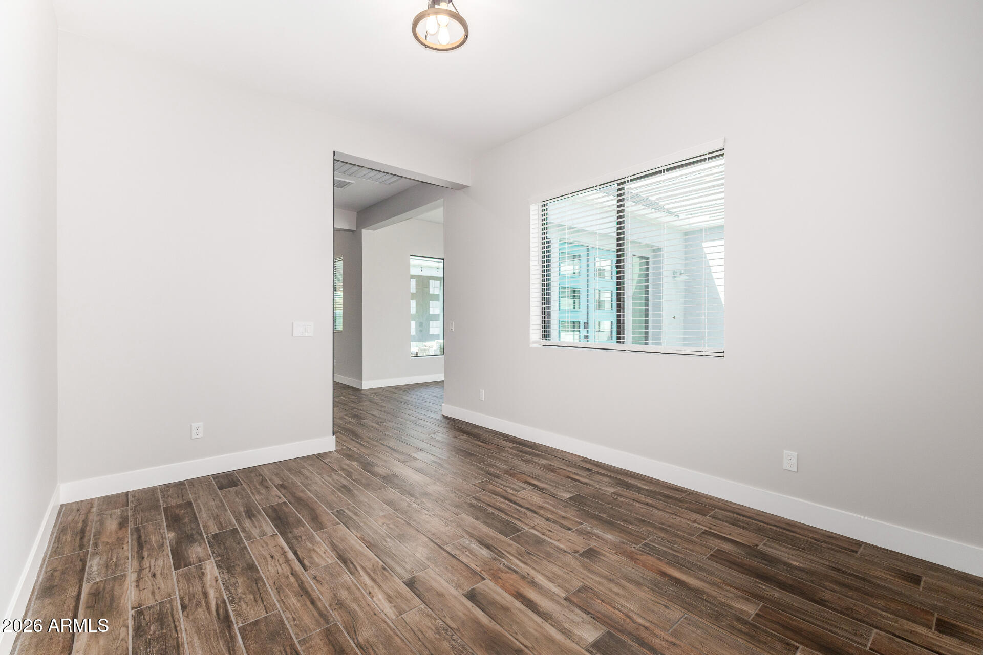 9818 South 7th Place Phoenix, AZ 85042 - Photo 19 of 62 an empty room with wooden floor and windows