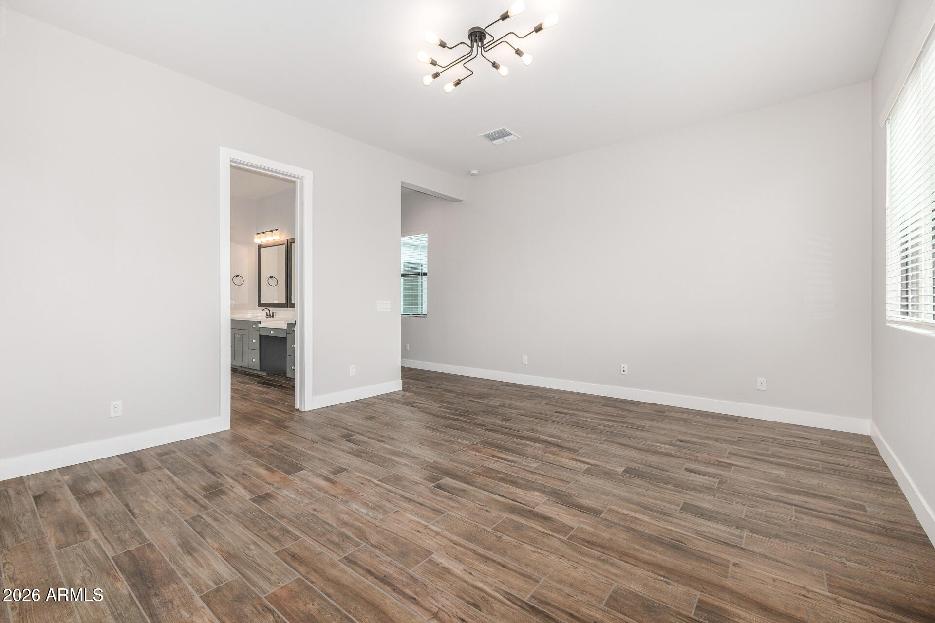 9818 South 7th Place Phoenix, AZ 85042 - Photo 21 of 62 a view of an empty room with wooden floor and a window