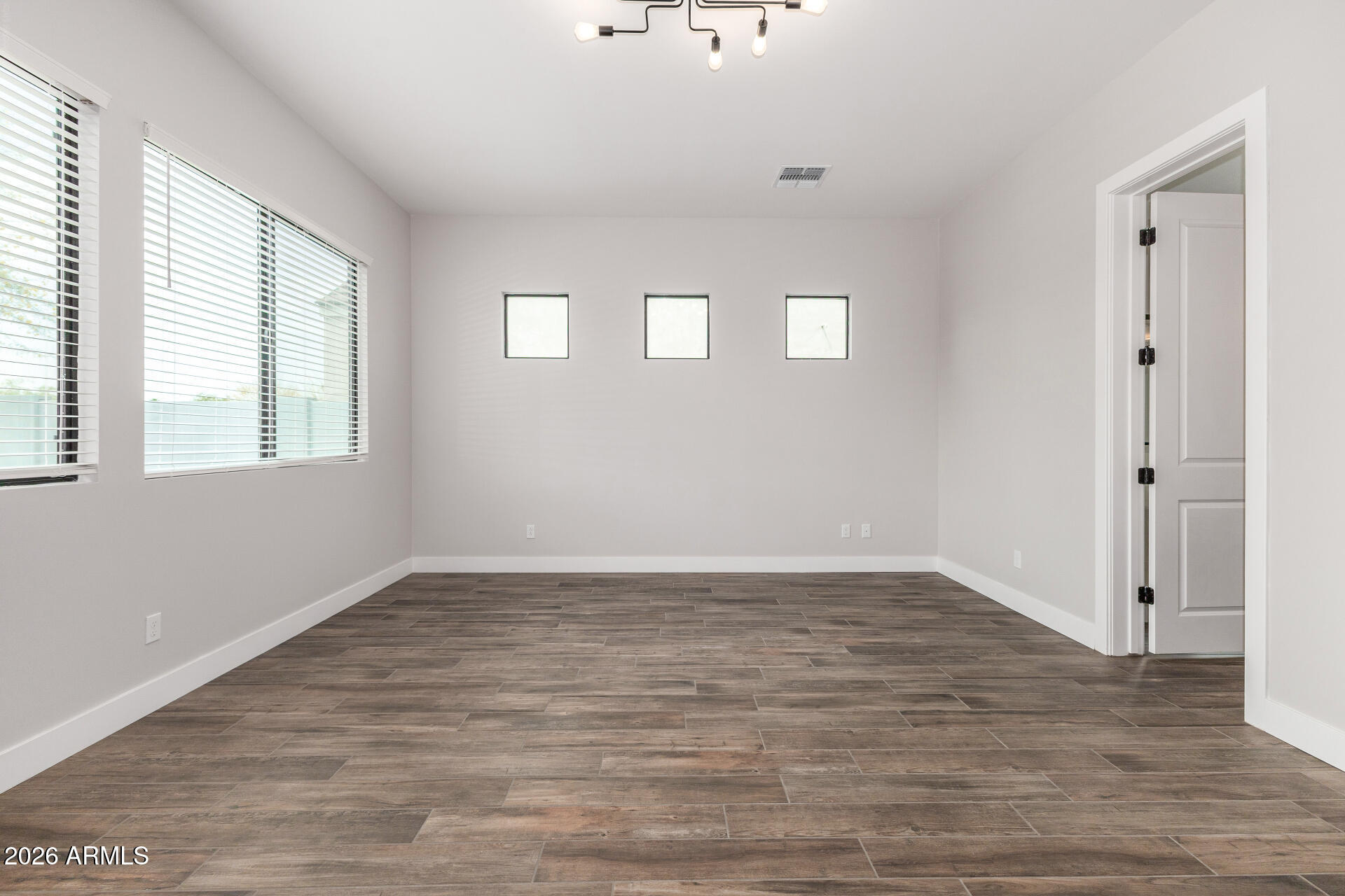 9818 South 7th Place Phoenix, AZ 85042 - Photo 22 of 62 a view of an empty room with wooden floor and a window