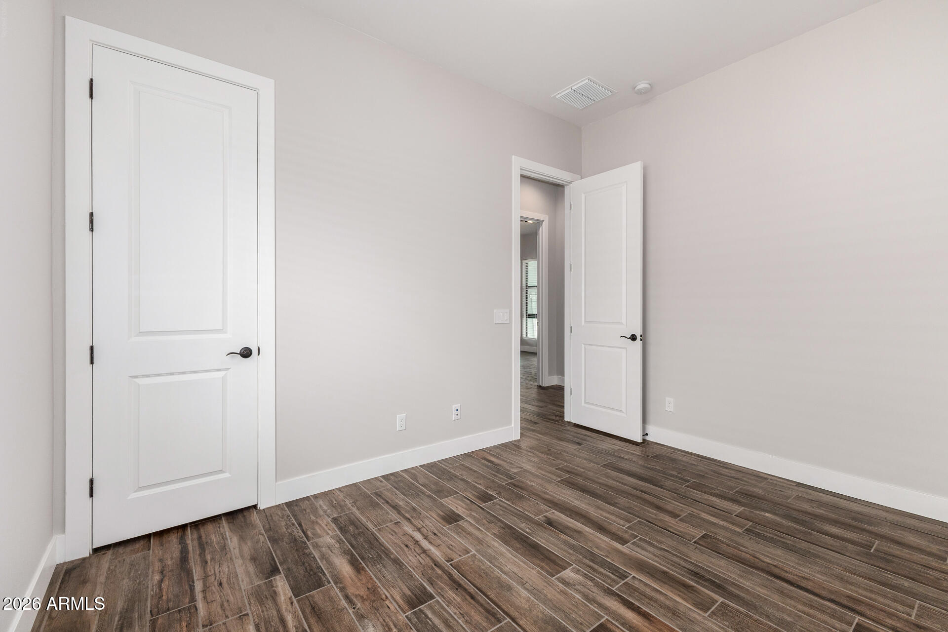 9818 South 7th Place Phoenix, AZ 85042 - Photo 27 of 62 a view of an empty room with wooden floor