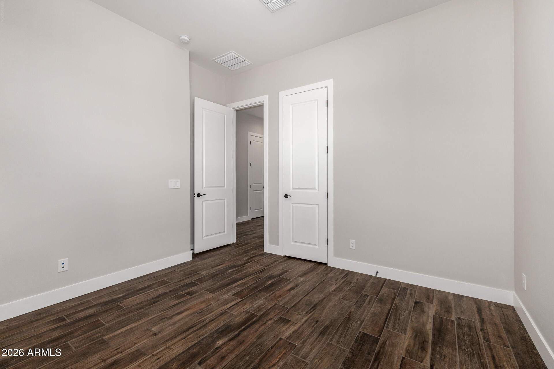 9818 South 7th Place Phoenix, AZ 85042 - Photo 28 of 62 a view of an empty room with wooden floor