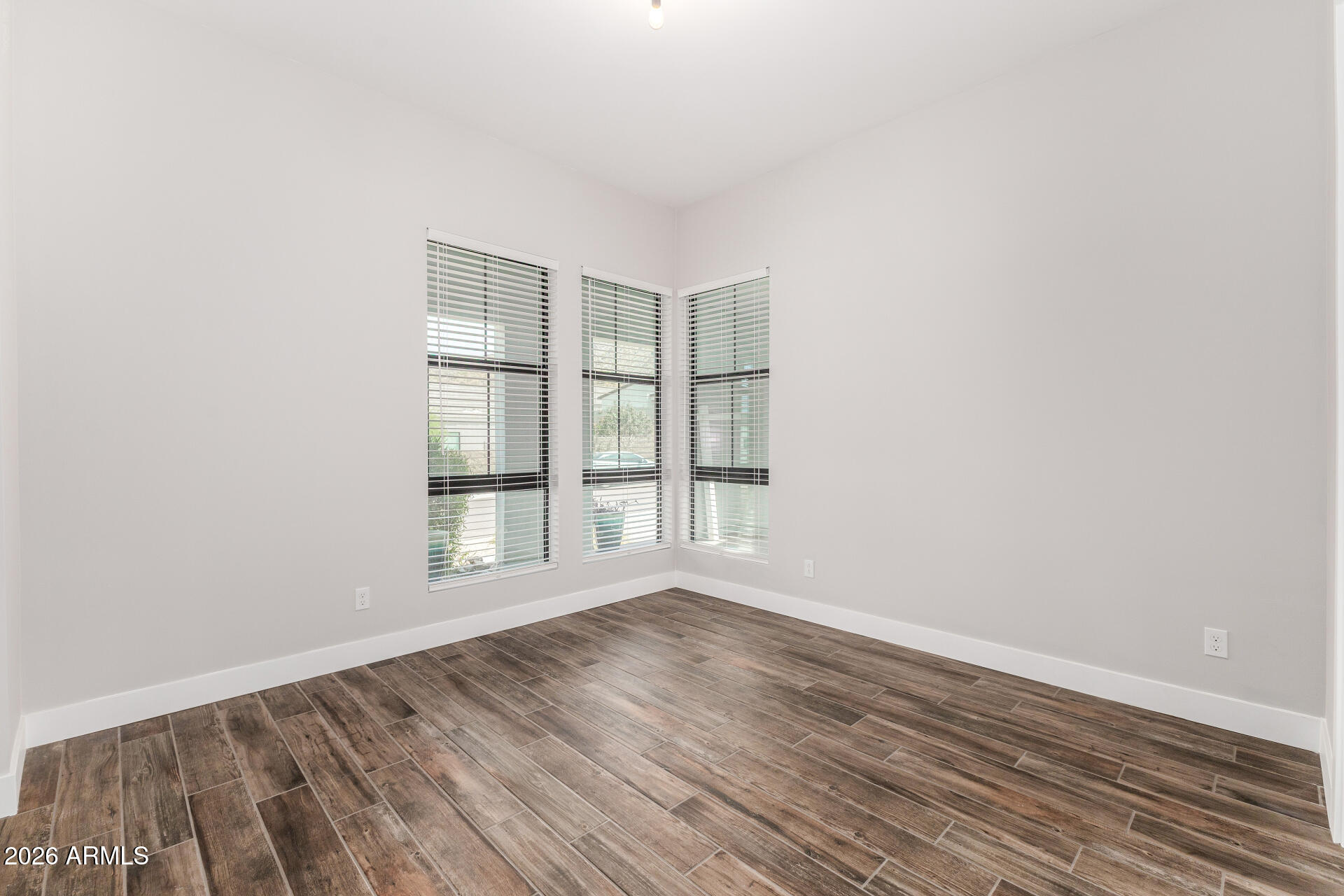 9818 South 7th Place Phoenix, AZ 85042 - Photo 29 of 62 an empty room with wooden floor and windows