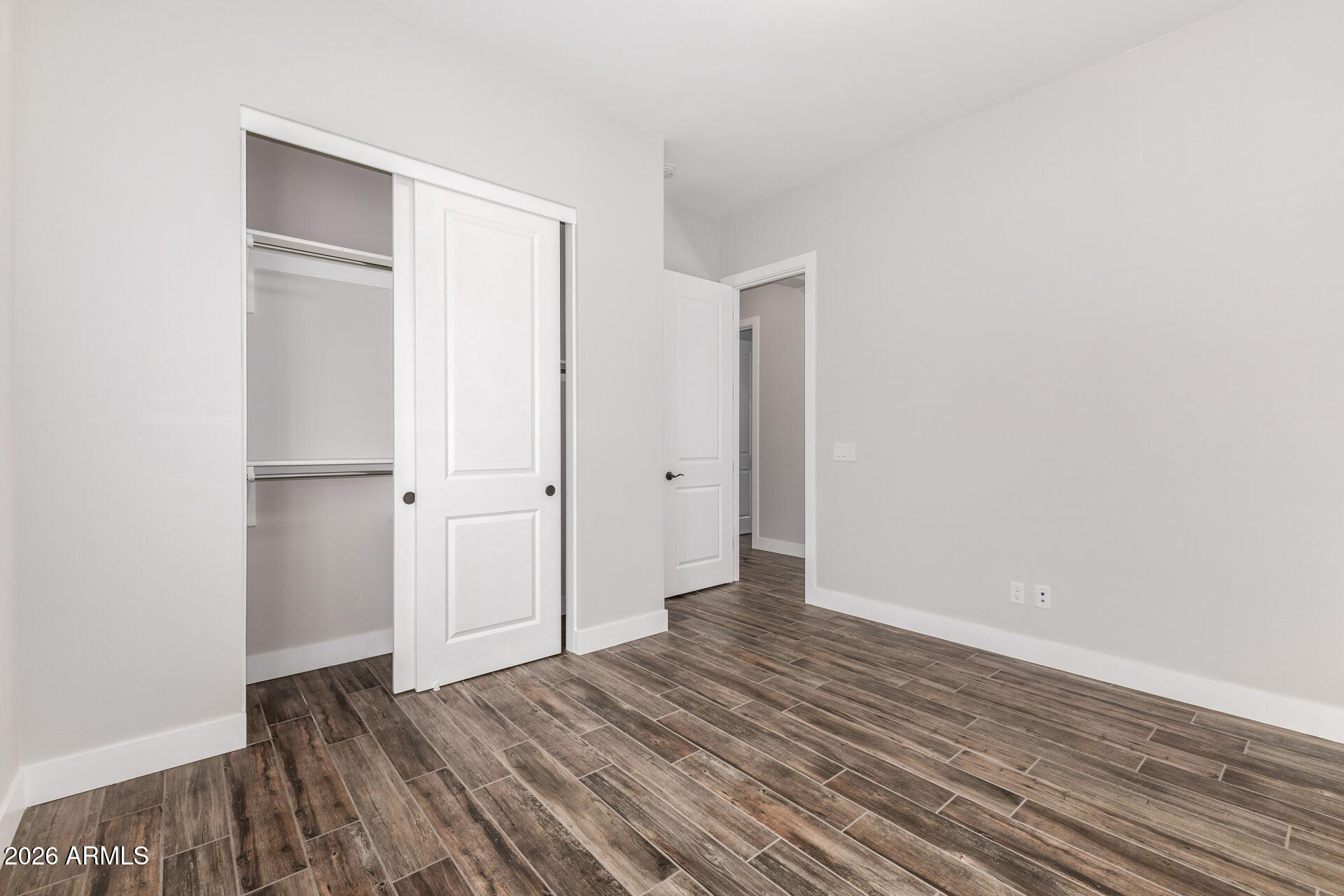 9818 South 7th Place Phoenix, AZ 85042 - Photo 34 of 62 a view of an empty room with wooden floor