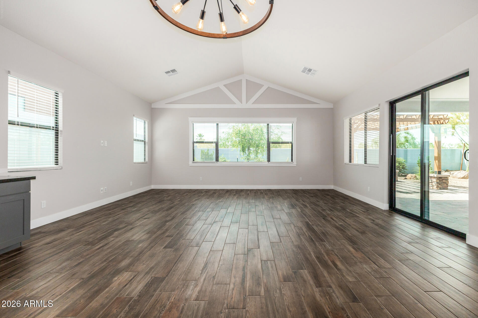 9818 South 7th Place Phoenix, AZ 85042 - Photo 9 of 62 an empty room with wooden floor and windows