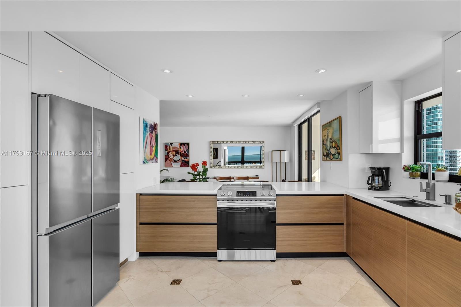 2333 Brickell Avenue, Unit 1401 Miami, FL 33129 - Photo 9 of 36 a kitchen with a sink a refrigerator and cabinets