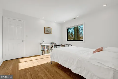 a bedroom with a bed and a large window