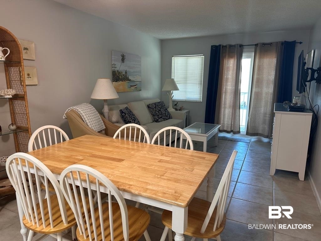 400 Plantation Road, Unit 1113 Gulf Shores, AL 36542 - Photo 4 of 26 Dining space featuring a textured ceiling and tile patterned flooring