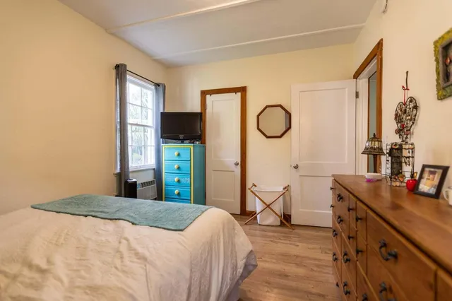 a bedroom with a bed dresser and a window