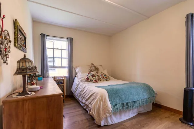 a bedroom with a bed and wooden floor