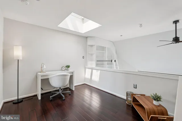 a view of a workspace with furniture and wooden floor