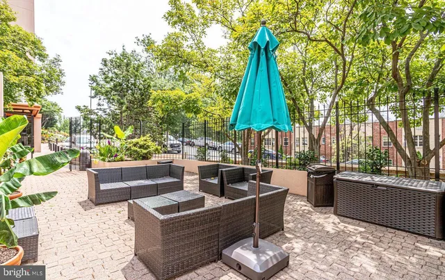 a view of patio with couches and a fire pit and large trees