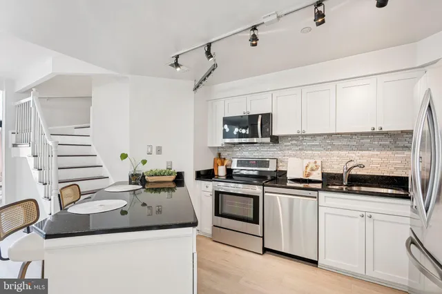 a kitchen with appliances a sink and cabinets