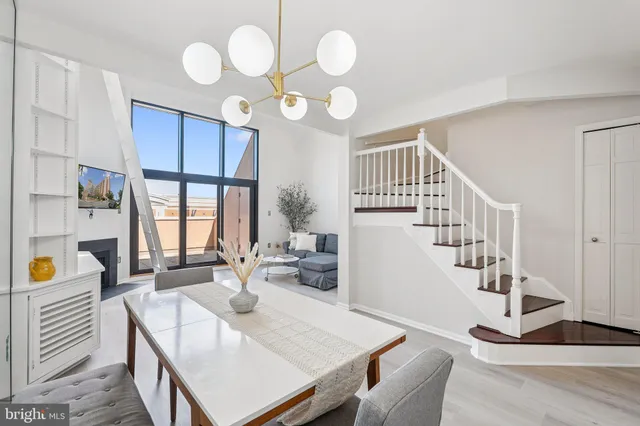 a view of a dining room and livingroom with furniture wooden floor windows and a chandelier