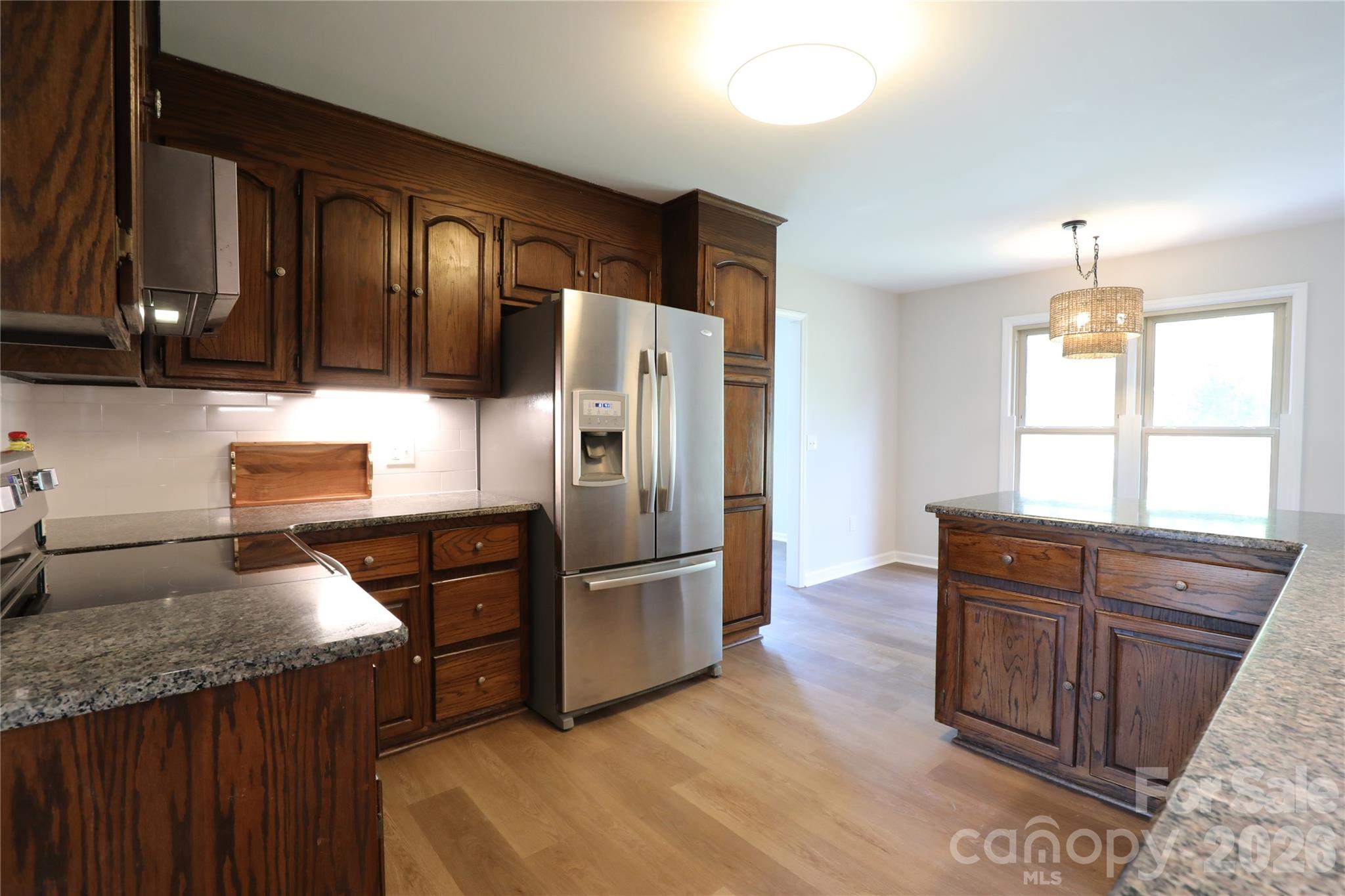 12809 Pine Bluff Road Midland, NC 28107 - Photo 10 of 41 a kitchen with granite countertop wooden cabinets a refrigerator and a sink