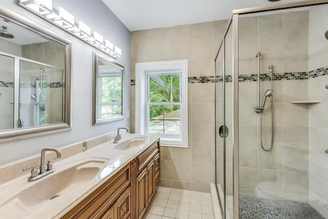 a bathroom with a tub sink shower and a mirror