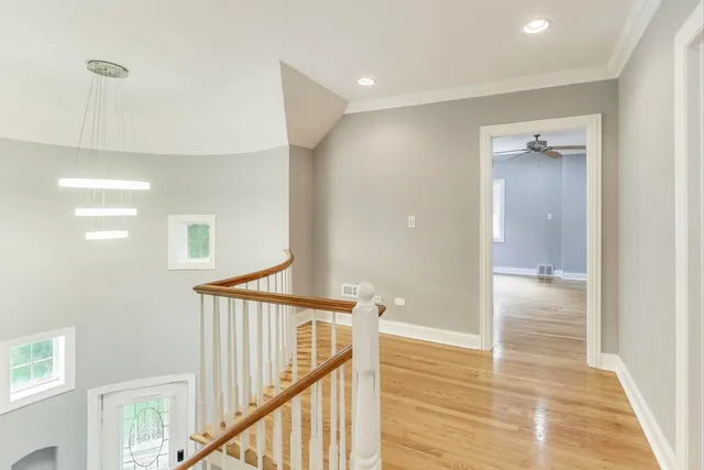 a view of a hallway with wooden floor and staircase
