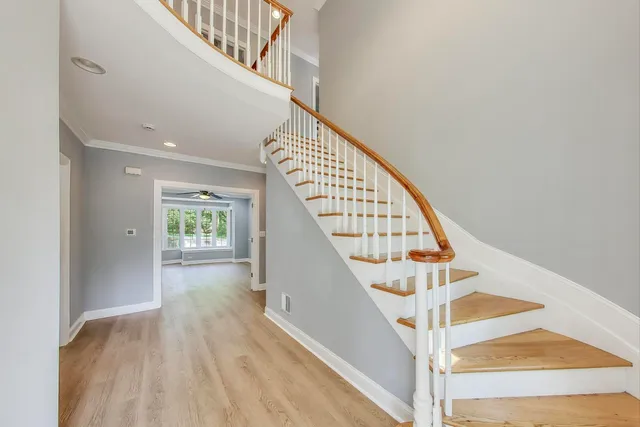 a view of staircase with wooden floor and white walls