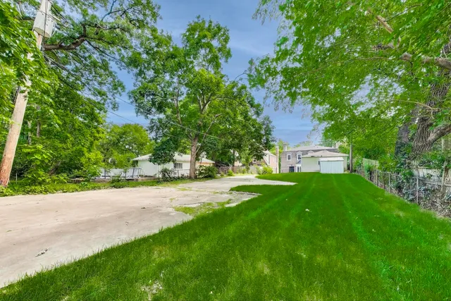 a view of a house with a yard and tree s