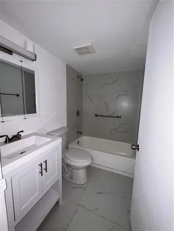 a bathroom with a toilet sink a mirror a bathtub and shower