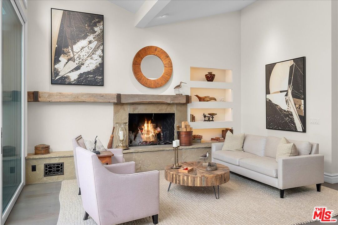 809 Leonard Road Los Angeles, CA 90049 - Photo 16 of 72 a living room with furniture a fireplace and wall paintings