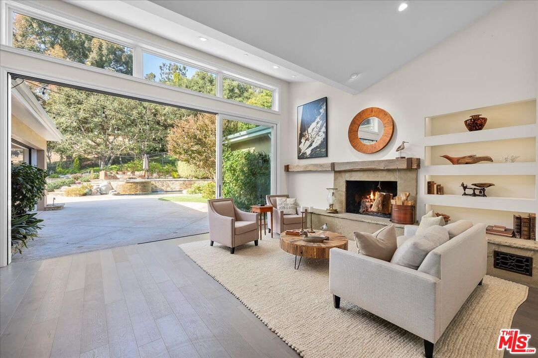 809 Leonard Road Los Angeles, CA 90049 - Photo 17 of 72 a living room with furniture a fireplace and a large window