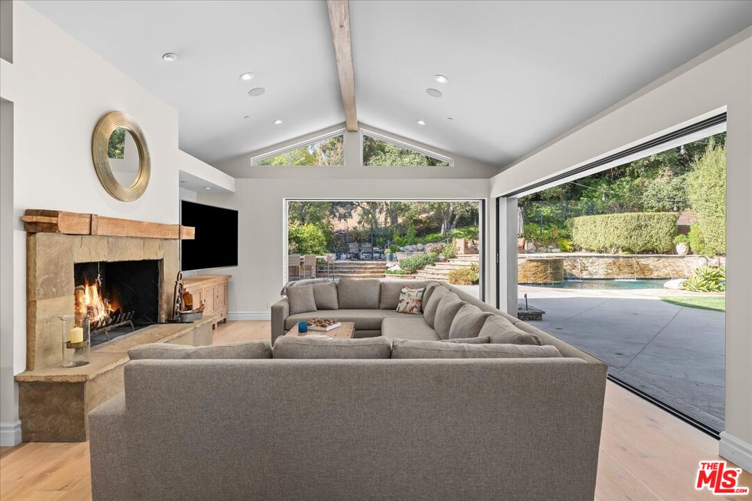 809 Leonard Road Los Angeles, CA 90049 - Photo 20 of 72 a living room with furniture a large window and a fireplace