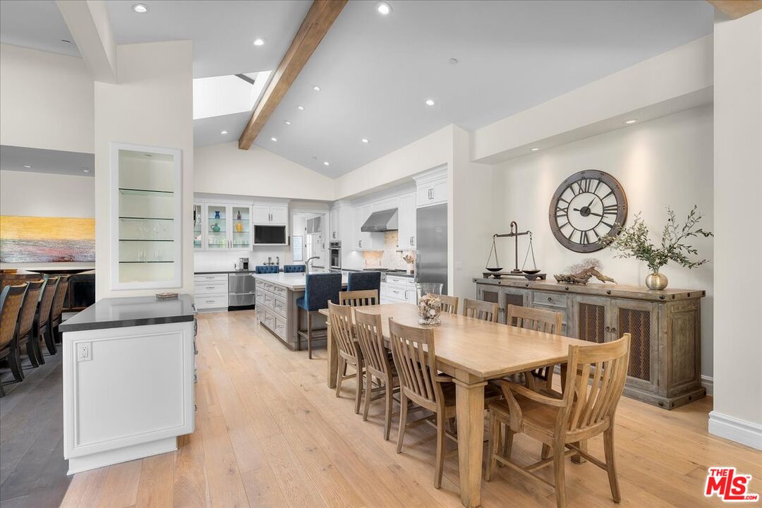 809 Leonard Road Los Angeles, CA 90049 - Photo 23 of 72 a dining room with furniture a clock and a view of kitchen