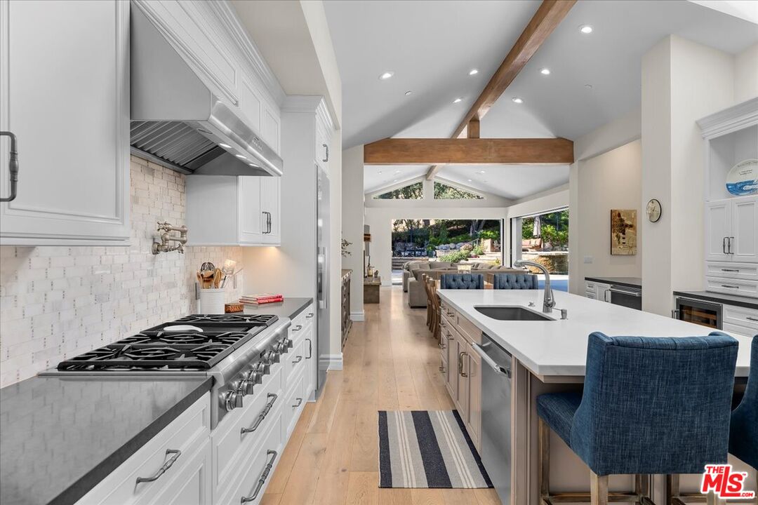809 Leonard Road Los Angeles, CA 90049 - Photo 27 of 72 a kitchen with stainless steel appliances granite countertop a stove a sink dishwasher and cabinets with wooden floor