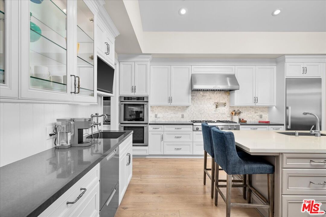 809 Leonard Road Los Angeles, CA 90049 - Photo 28 of 72 a kitchen with stainless steel appliances granite countertop a sink stove and refrigerator