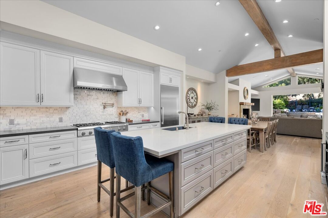 809 Leonard Road Los Angeles, CA 90049 - Photo 29 of 72 a large kitchen with kitchen island a island a sink a stove and a refrigerator