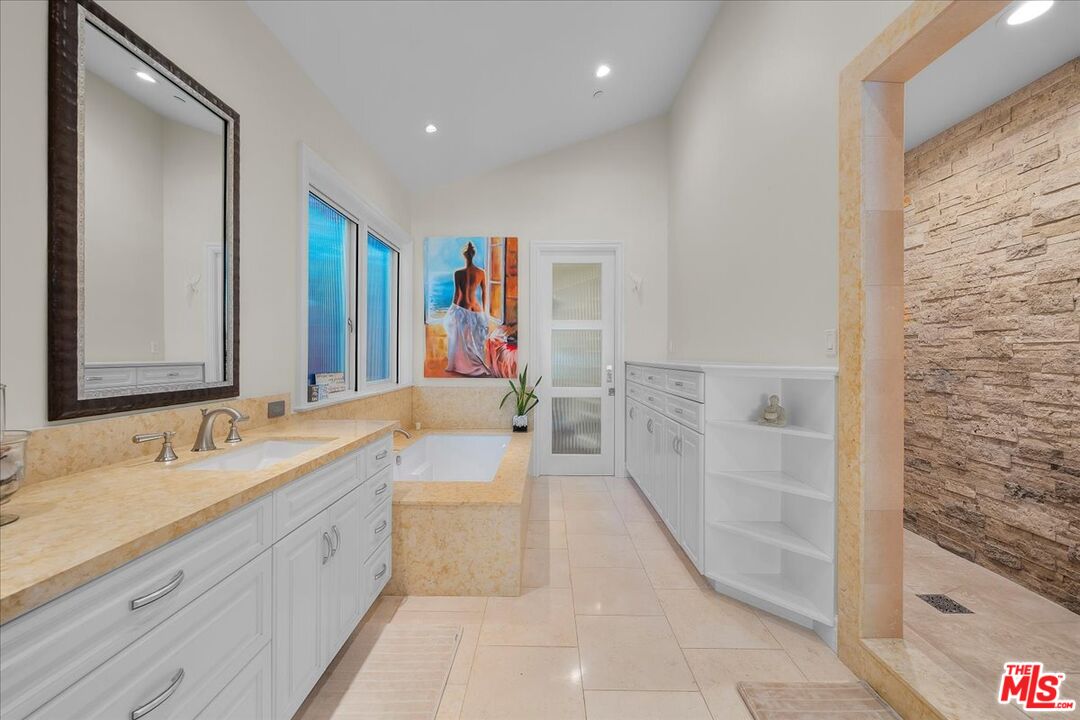 809 Leonard Road Los Angeles, CA 90049 - Photo 43 of 72 a spacious bathroom with a bathtub sink and mirror