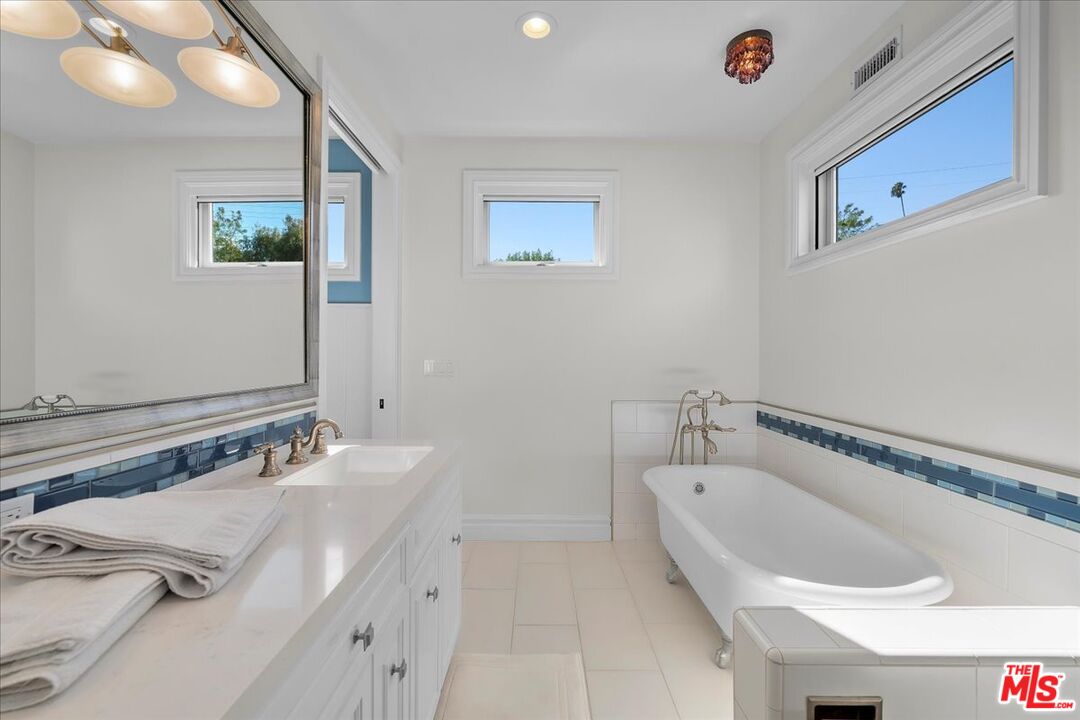 809 Leonard Road Los Angeles, CA 90049 - Photo 52 of 72 a bathroom with a tub sink and mirror