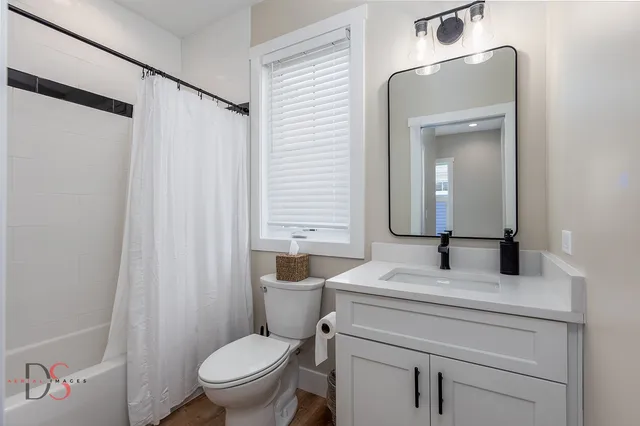 a bathroom with a granite countertop sink toilet and mirror