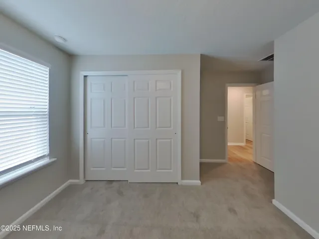 an empty room with windows and closet