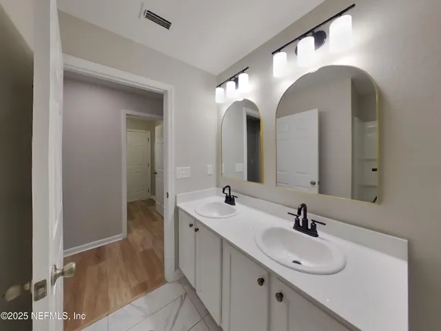 a bathroom with a double vanity sink and mirror