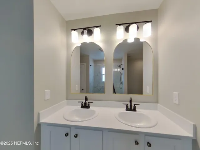 a bathroom with double vanity sinks and a mirror