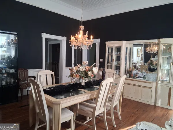 a dining room with furniture a chandelier and window