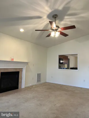 a living room with a fireplace and a ceiling fan