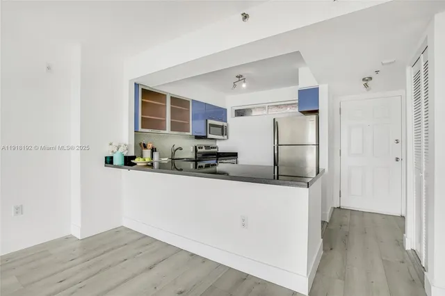 a kitchen with stainless steel appliances a refrigerator and a stove top oven