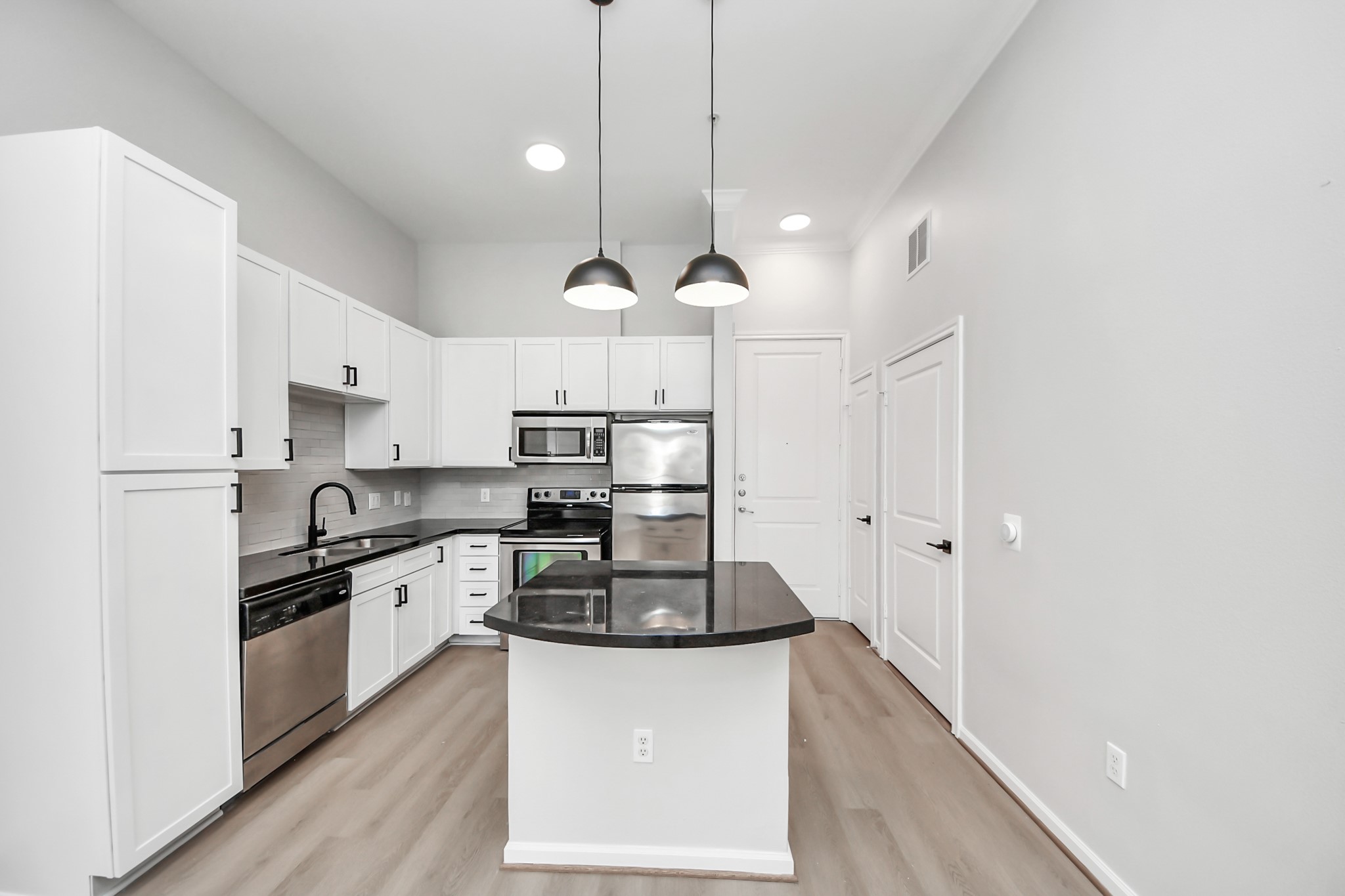 6363 San Felipe Street, Unit 549 Houston, TX 77057 - Photo 7 of 43 a kitchen with stainless steel appliances granite countertop a sink a stove a refrigerator and island with wooden floor