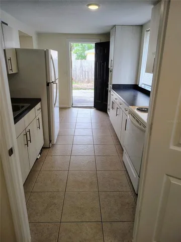 a kitchen with stainless steel appliances a refrigerator a sink a stove a microwave a counter top and a window