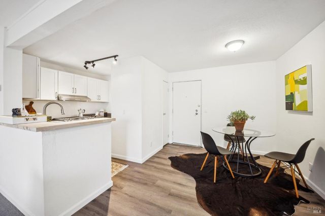 a living room with stainless steel appliances granite countertop furniture and a wooden floor