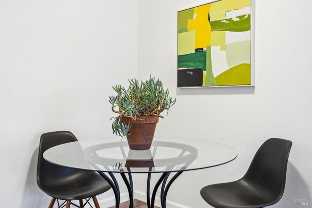 a dining room with furniture and a potted plant